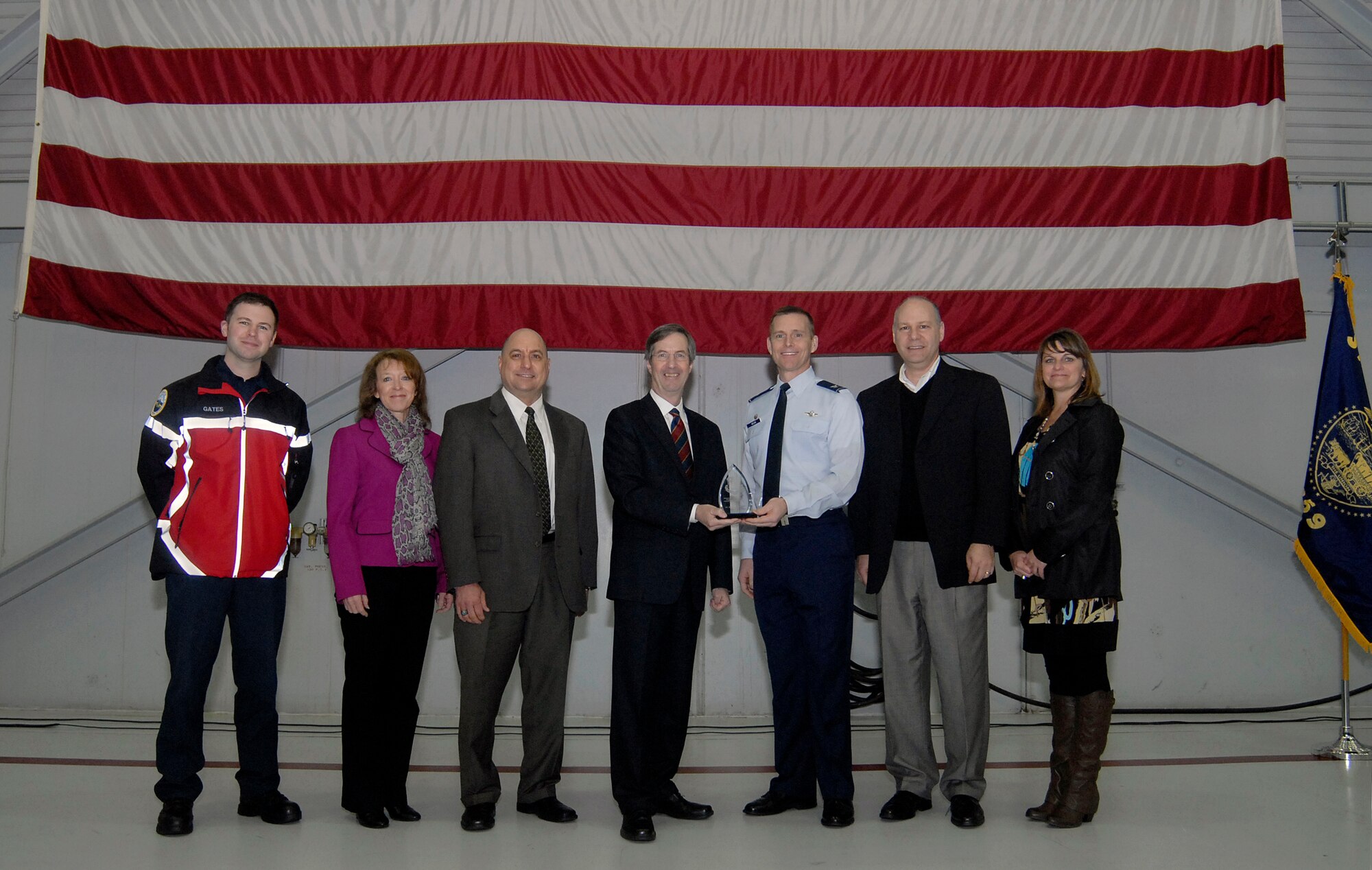 Standing with staff members of the Portland of Portland, Col. Rick Wedan, 142nd Fighter Wing Commander, and Bill Wyatt Executive Director for the Port of Portland, hold the award for the Oregon Air National Guard Employer of the Year award for 2013 during a ceremony at the Portland Air National Guard Base, Ore., Feb., 2014. (Air National Guard photo by Tech. Sgt. John Hughel, 142nd Fighter Wing Public Affairs/Released)