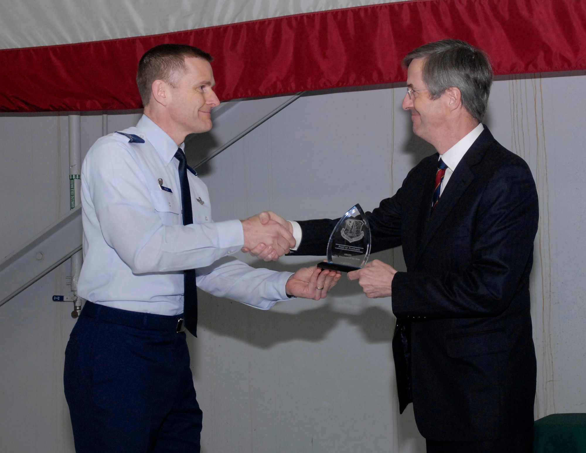 Oregon Air National Guard Col. Rick Wedan, 142nd Fighter Wing Commander, congratulates Mr. Bill Wyatt, Executive Director for the Port of Portland, during the ceremony for the Oregon Air National Guard Employer of the Year award for 2013, held at the Portland Air National Guard Base, Ore., Feb. 20, 2014. (Air National Guard photo by Tech. Sgt. John Hughel, 142nd Fighter Wing Public Affairs/Released)