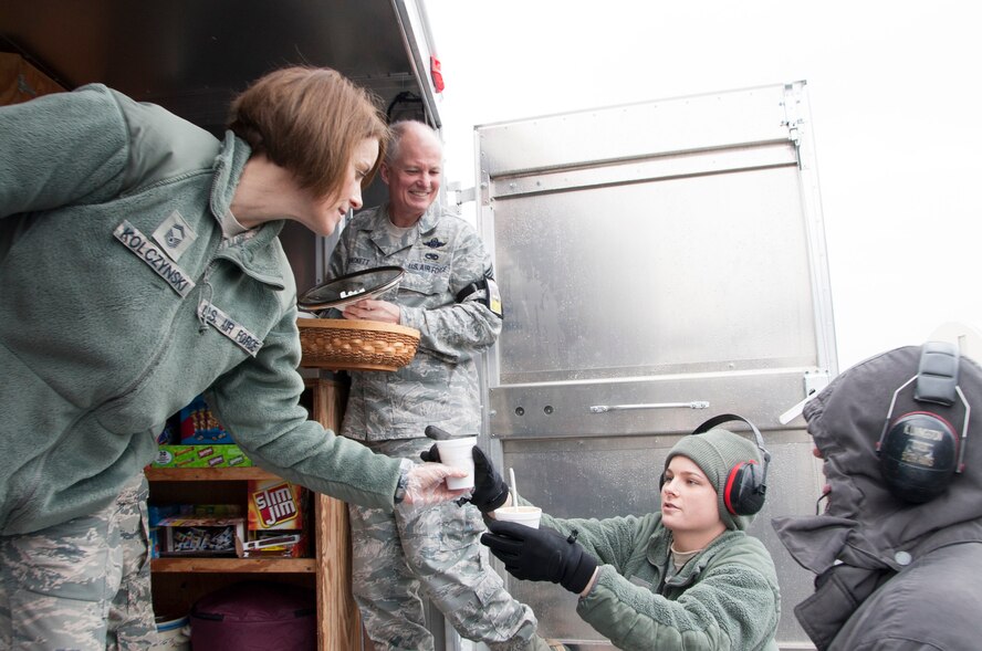 Senior Master Sgt. Dawn Kolczynski, 436th Airlift Wing Chiefs Group, hands Airman Tessa Bonham, 436th Aircraft Maintenance Squadron electronic warfare technician, a cup of hot chocolate Feb. 19, 2014, Dover Air Force Base, Del. A small cup of chili was also provided by the Chiefs Group to help boost morale. (U.S. Air Force photo/ Senior Airman Jared Duhon)