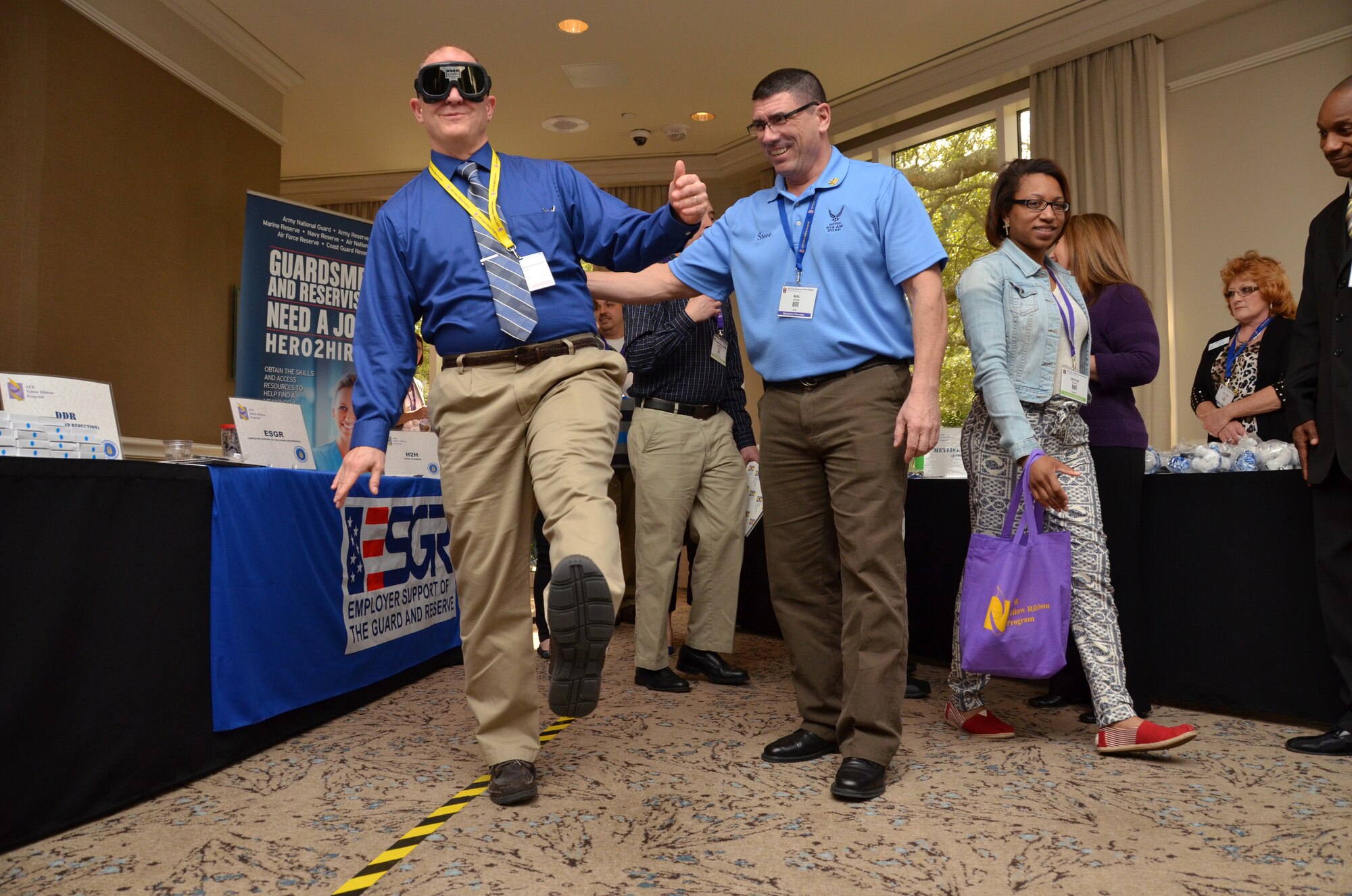 SMSgt. Mal Brown, drug demand and reduction coordinator, assists one of the attendees while he 'walks the line' wearing "drunk goggles"  during Yellow Ribbon Reintegration Program, Hilton Head, S.C., February 22, 2014 as part of a demonstration. (U.S. Air Force photo/SSgt. Kelly Goonan)