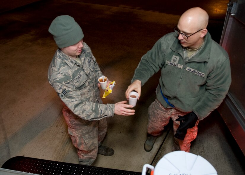 Senior Master Sgt. Patrick Piazza, 436th Maintenance Squadron maintenance flight superintendent, hands Senior Airman Ben Fugler, 436th Aircraft Maintenance Squadron crew chief, a cup of hot chocolate Feb. 19, 2014, at Dover Air Force Base, Del. Piazza is the vice president of Dover Chiefs Group. (U.S. Air Force photo/Airman 1st Class Zachary Cacicia) 