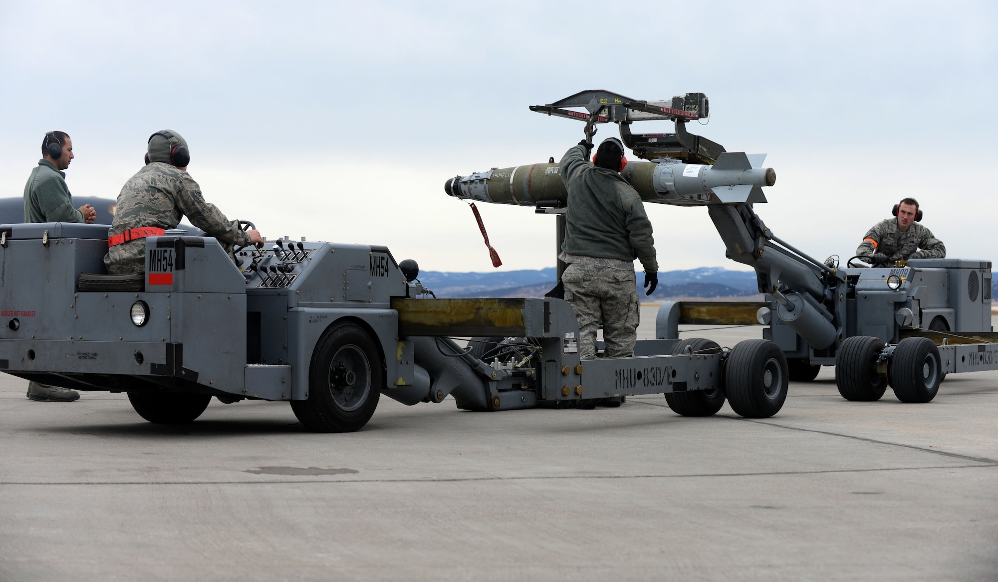 Load crew members from the 28th Aircraft Maintenance Squadron transfer a GBU-54 from a transfer jammer onto a ram jammer during the Combat Hammer exercise at Ellsworth Air Force Base, S.D., Feb. 14, 2014. The process of weapons handling was evaluated from start to finish during the exercise that assesses the effectiveness, maintainability, suitability and accuracy of employing precision guided munitions.  (U.S. Air Force photo by Airman 1st Class Rebecca Imwalle/ Released)