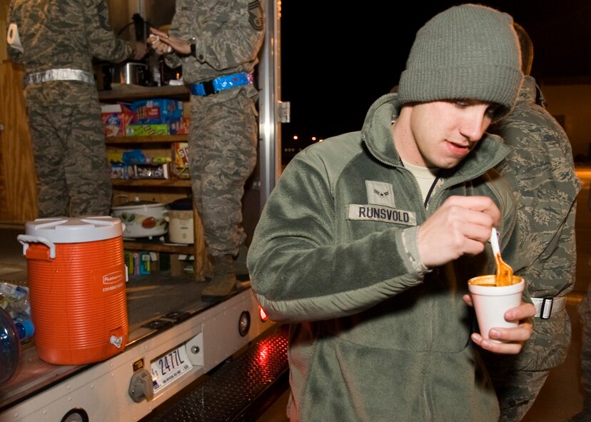 Airman 1st Class Colton Runsvold, 436th Aircraft Maintenance Squadron crew chief, eats a cup of chili provided to him by the Dover Chiefs Group Feb. 19, 2014, on the flight line at Dover Air Force Base, Del. The Dover Chiefs Group partnered with DAFB’s chaplains to provide chili and hot chocolate to Airmen working all around the base. (U.S. Air Force photo/Airman 1st Class Zachary Cacicia)