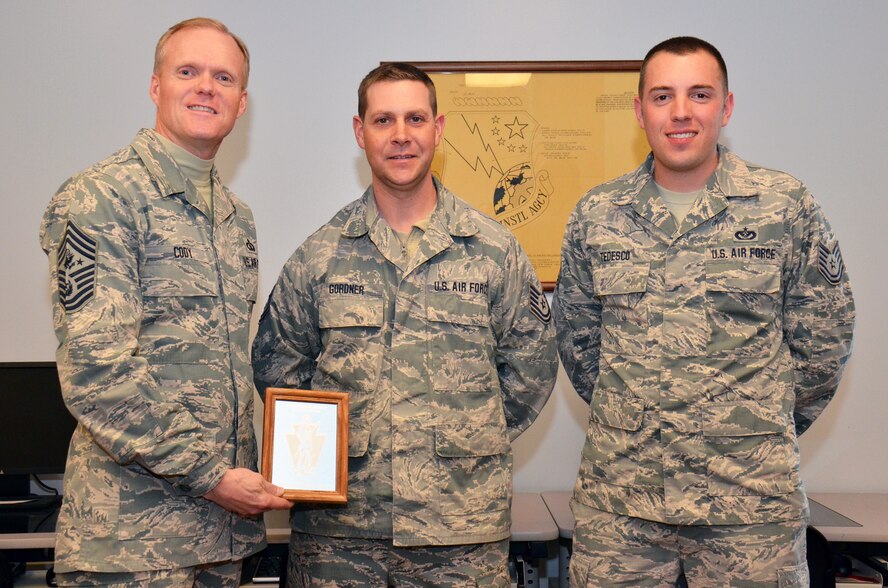 Instructors Tech. Sgt. Jason Gordner and Tech. Sgt. Mike Tedesco present Chief Master Sgt. of the Air Force James Cody with a memento commemorating his visit to the Lightning Force Academy and Regional Equipment Operators Training Site, 193rd Regional Support Group, 193rd Special Operations Wing, Pennsylvania Air National Guard, at Fort Indiantown Gap, Annville, Pa., Feb. 23, 2014. Chief Cody visited the 193rd Feb. 22-23 to get a firsthand look at the wing's missions at Middletown, Pa., and Fort Indiantown Gap, Annville, Pa., and to speak with Airmen about challenges they face. (U.S. Air National Guard photo by Tech. Sgt. Ted Nichols/Released)