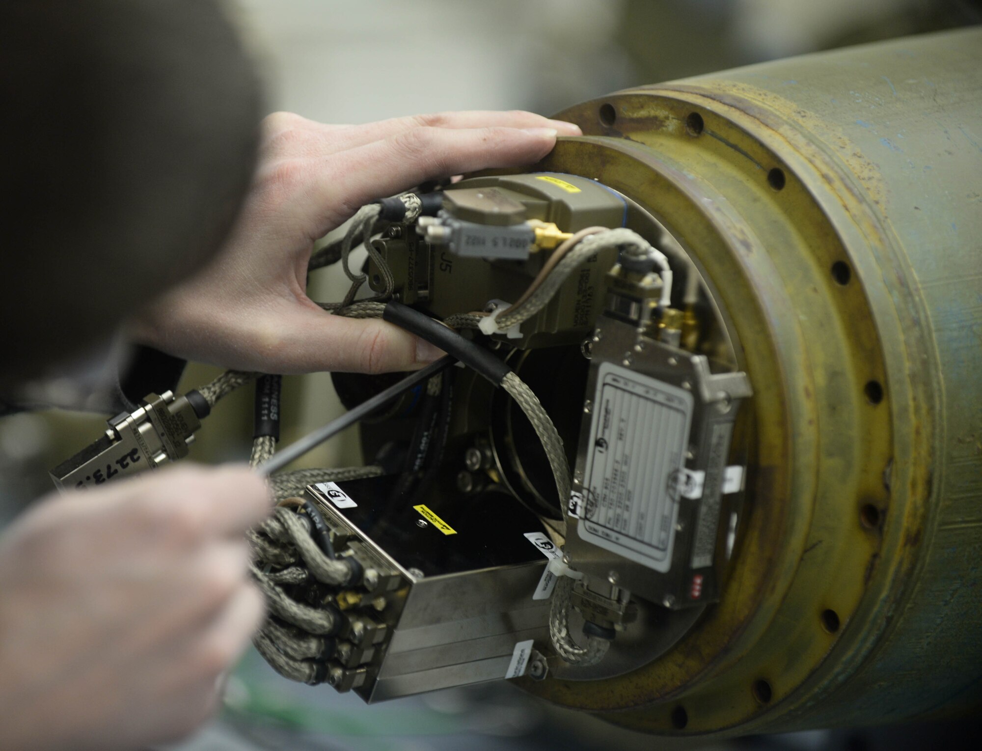 Patrick Pasierb, Joint Direct Attack Munitions Systems Program Office engineer, assembles a GBU-31 Laser Joint Direct Attack Munition at Ellsworth Air Force Base, S.D., Feb. 11, 2014. Pasierb assisted Airmen of the 28th Munitions Squadron with building munitions during the exercise, designed to evaluate the effectiveness, maintainability, suitability and accuracy of precision guided munitions and other advanced air to ground weapons. (U.S. Air Force photo by Senior Airman Zachary Hada/Released)