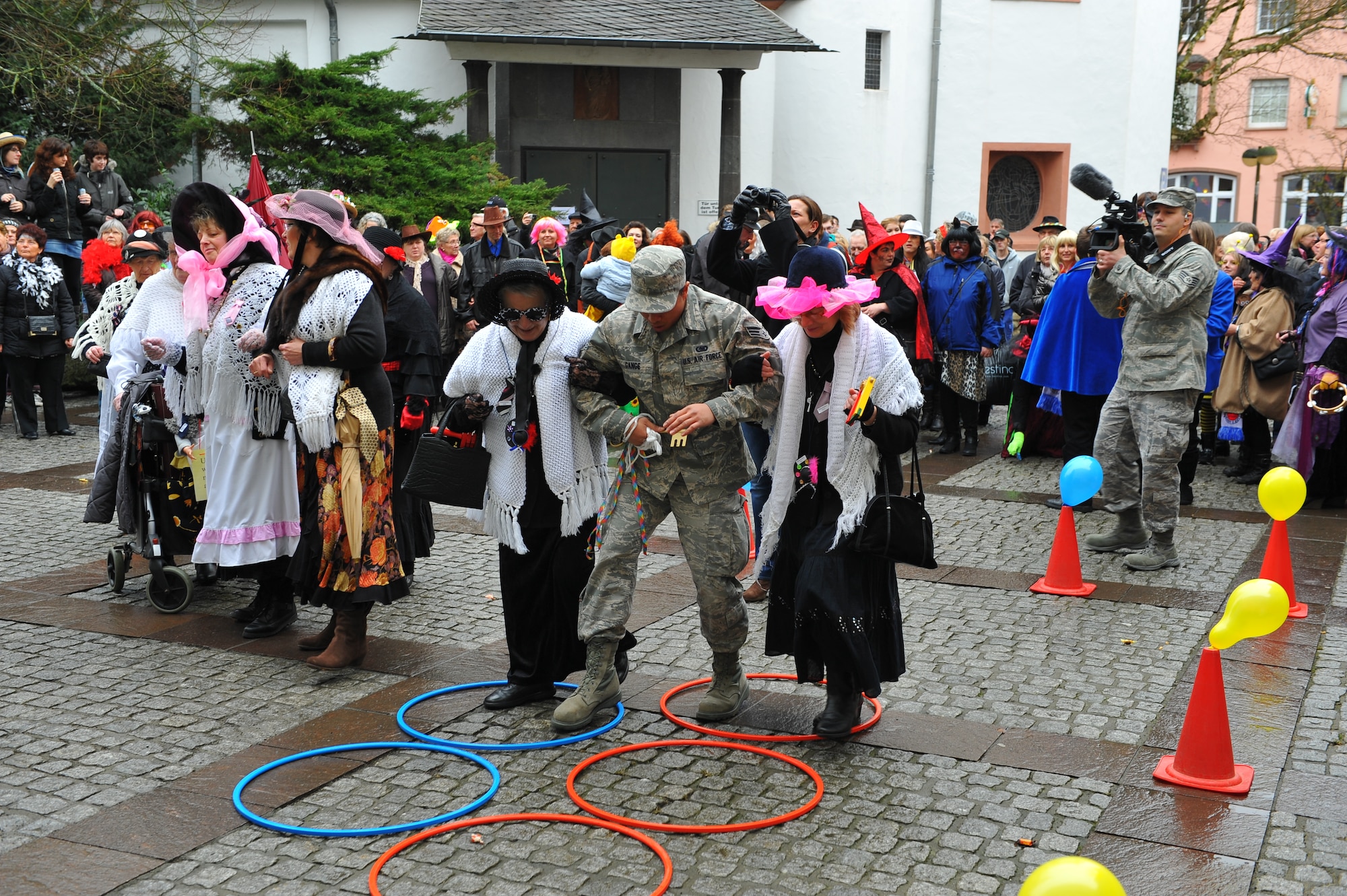 Senior Airman Urzus Gange, an engine supply technician from 52nd Logistics Readiness Squadron, is guided through hoops by female Bitburg citizens during a Fashing event at Bitburg, Germany, Feb. 16, 2012. During the German holiday tradition, Spangdahlem Airmen participate in the event by keeping the city's ceremonial key away from the Fashing "fool ladies." (U.S. Air Force photo Airman 1st Class Dillon Davis / Released) 