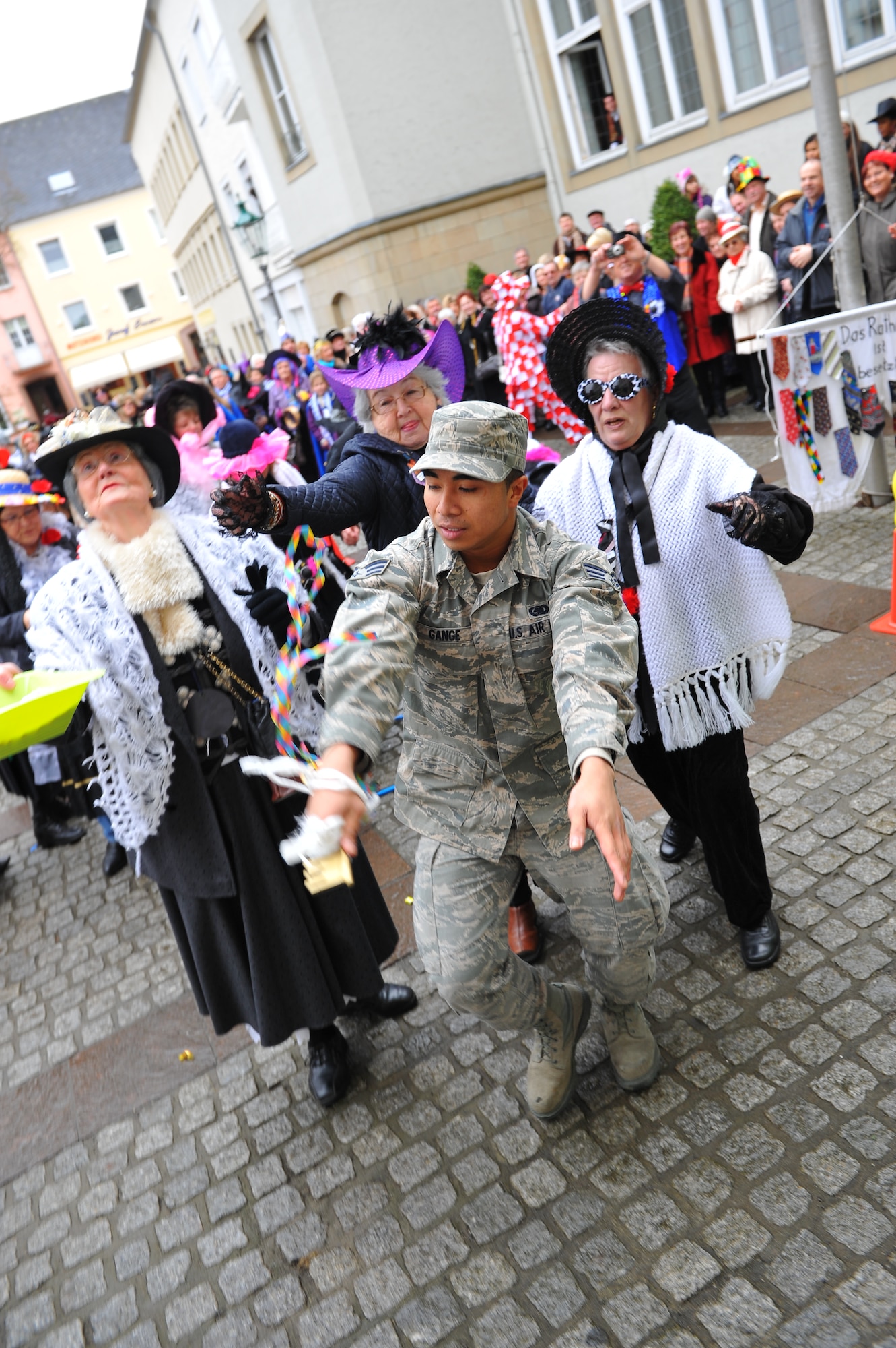 Senior Airman Urzus Gange, an engine supply technician from 52nd Logistics Readiness Squadron, runs through a street chased by female Bitburg citizens as part of a German tradition during a Fashing event at Bitburg, Germany, Feb. 16, 2012. During the German holiday tradition, the mayor of Bitburg invited a delegation from Spangdahlem Air Base to help him defend the city hall and its ceremonial key from the Fashing "fool ladies." (U.S. Air Force photo Airman 1st Class Dillon Davis / Released) 