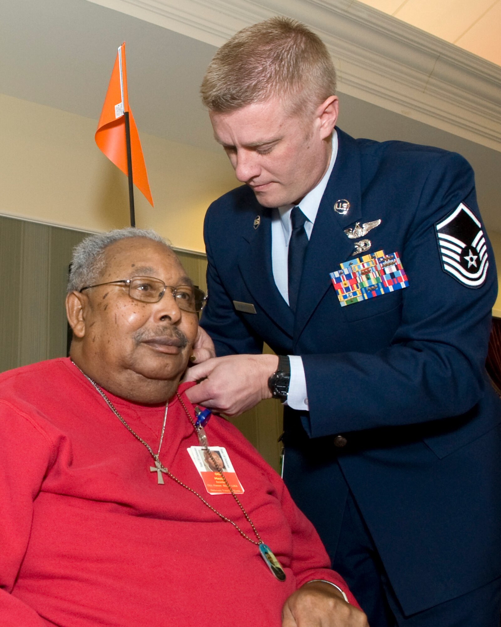 Master Sgt. Robert McGriffin, 9th Airlift Squadron loadmaster, pins a commemorative pin onto Otis Mason, U.S. Marine Corps and U.S. Air Force veteran, at a five year recognition event Feb. 19, 2014, at the Delaware Veterans Home (DVH) in Milford, Del. Mason has called the DVH his home for over six years. (U.S. Air Force photo/Airman 1st Class Zachary Cacicia)