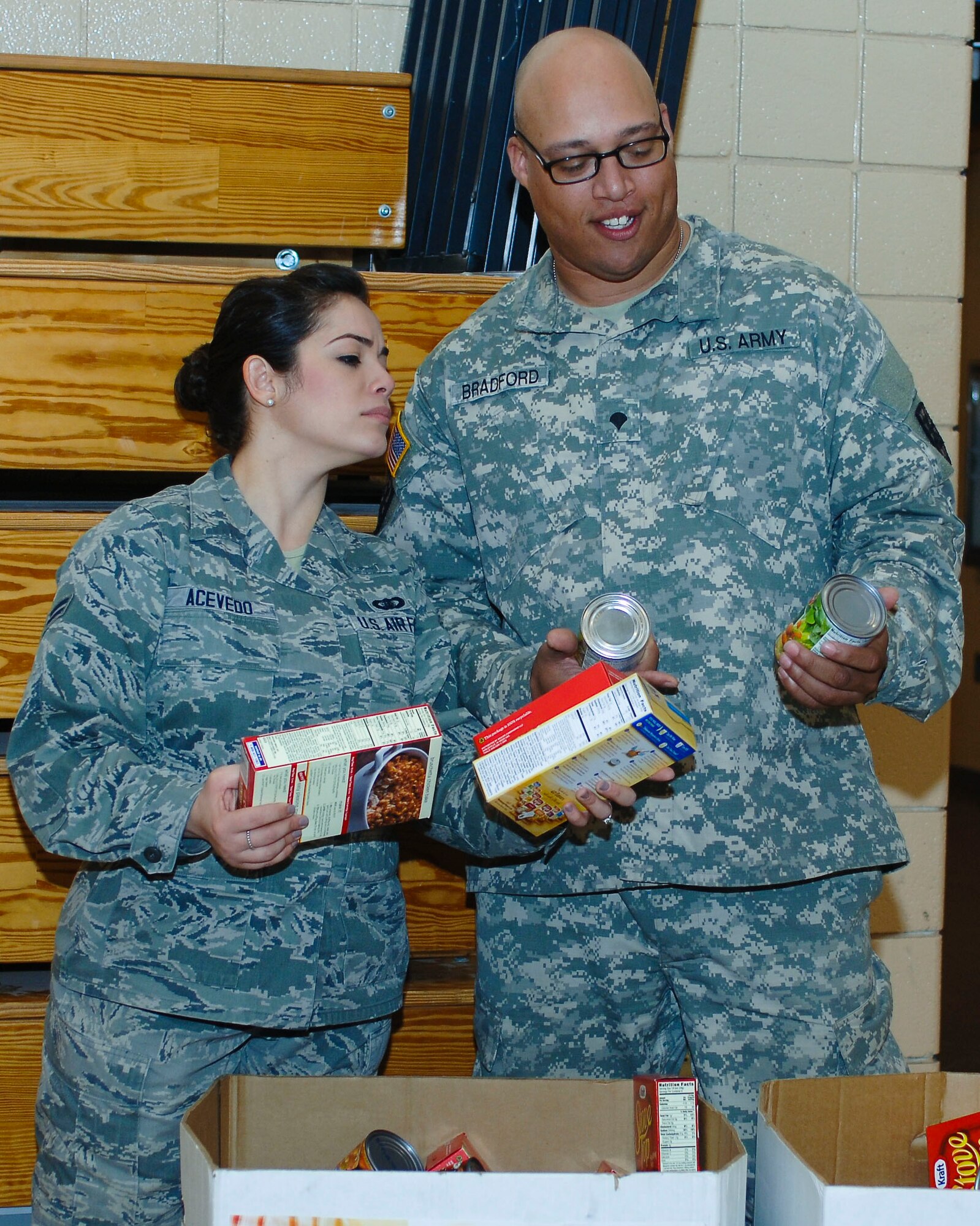 U.S. Air Force Airman 1st Class Mara Acevedo, Airmen Committed to Excellence president, and U.S. Army Spc. Adam Bradford, Better Opportunities for Single Soldiers vice president, sort food during the “Share the Love” food drive at Langley Air Force Base, Va., Feb. 20, 2014. This was the first event coordinated by ACE and BOSS together. Acevedo hails from Puerto Rico, and Bradford is a Honolulu native. (U.S. Air Force photo by Senior Airman Teresa Aber/Released)