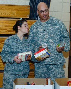 U.S. Air Force Airman 1st Class Mara Acevedo, Airmen Committed to Excellence president, and U.S. Army Spc. Adam Bradford, Better Opportunities for Single Soldiers vice president, sort food during the “Share the Love” food drive at Langley Air Force Base, Va., Feb. 20, 2014. This was the first event coordinated by ACE and BOSS together. Acevedo hails from Puerto Rico, and Bradford is a Honolulu native. (U.S. Air Force photo by Senior Airman Teresa Aber/Released)
