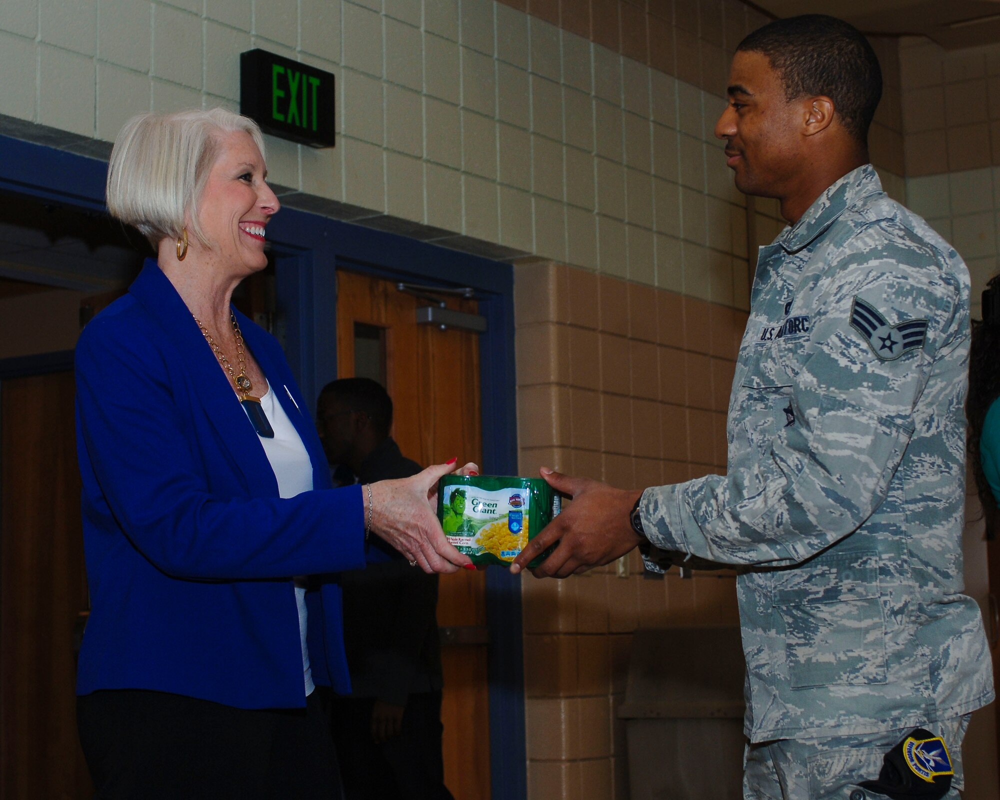 U.S. Air Force Senior Airman Marlon Harris, 633rd Security Forces Squadron entry controller, gives his donation to Donna Tighe, Virginia Peninsula Food Bank food drive coordinator during the “Share the Love” food drive at Langley Air Force Base, Va., Feb. 20, 2014. The “Share the Love” food drive and a secondary drive produced more than 500 pounds of food for the VPFB. (U.S. Air Force photo by Senior Airman Teresa Aber/Released)