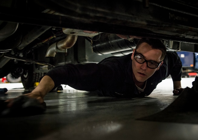 Senior Airman Benjamin Kingston, 628th Logistics Readiness Squadron vehicle maintainer journeyman, uses a rag to clean up a spill underneath a deicer vehicle he performed maintenance on Feb. 11, 2014, at Joint Base Charleston, S.C. Vehicle maintenance technicians maintain JB Charleston's entire vehicle fleet, keeping cars, trucks and buses operating smoothly. (U.S. Air Force photo/ Senior Airman Dennis Sloan)