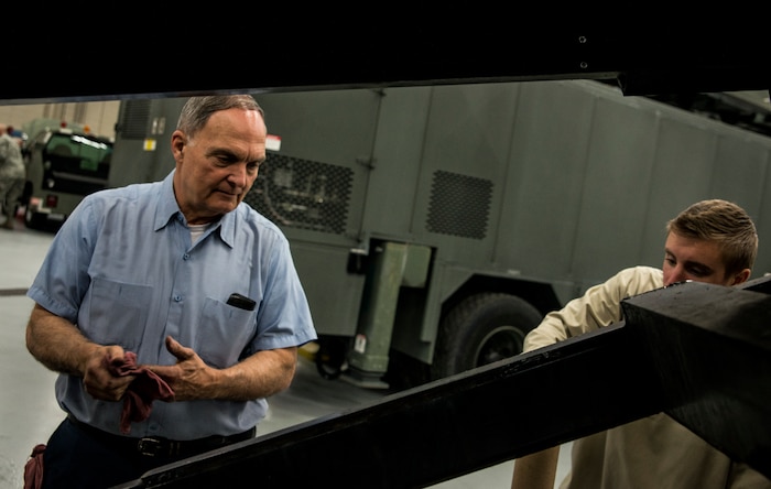 James Brown, 628th Logistics Readiness Squadron lead civilian maintenance craftsman, works with Airman 1st Class Zachary Pforr, 628th LRS vehicle maintainer apprentice, on a baggage loading cart used on the flightline Feb. 11, 2014, at Joint Base Charleston, S.C. Vehicle maintenance technicians maintain JB Charleston's entire vehicle fleet, keeping cars, trucks and buses operating smoothly. (U.S. Air Force photo/ Senior Airman Dennis Sloan)
