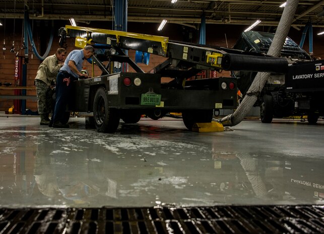 James Brown, 628th Logistics Readiness Squadron lead civilian maintenance craftsman, works with Airman 1st Class Zachary Pforr, 628th LRS vehicle maintainer apprentice, on a baggage loading cart used on the flightline Feb. 11, 2014, at Joint Base Charleston, S.C. Vehicle maintenance technicians maintain JB Charleston's entire vehicle fleet, keeping cars, trucks and buses operating smoothly. (U.S. Air Force photo/ Senior Airman Dennis Sloan)