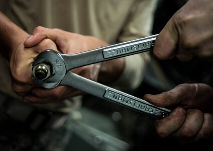 Airmen from the 628th Logistics Readiness Squadron use wrenches to remove a bolt from a vehicle part Feb. 11, 2014, at Joint Base Charleston, S.C. Vehicle maintenance technicians maintain JB Charleston's entire vehicle fleet, keeping cars, trucks and buses operating smoothly. (U.S. Air Force photo/ Senior Airman Dennis Sloan)