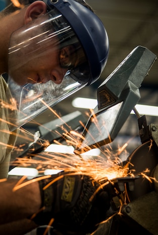 Senior Airman Anthony Williams, 628th Logistics Readiness Squadron vehicle maintainer journeyman, uses a bench grinder to sharpen a chisel Feb. 11, 2014, at Joint Base Charleston, S.C. Vehicle maintenance technicians maintain JB Charleston's entire vehicle fleet, keeping cars, trucks and buses operating smoothly. (U.S. Air Force photo/ Senior Airman Dennis Sloan)