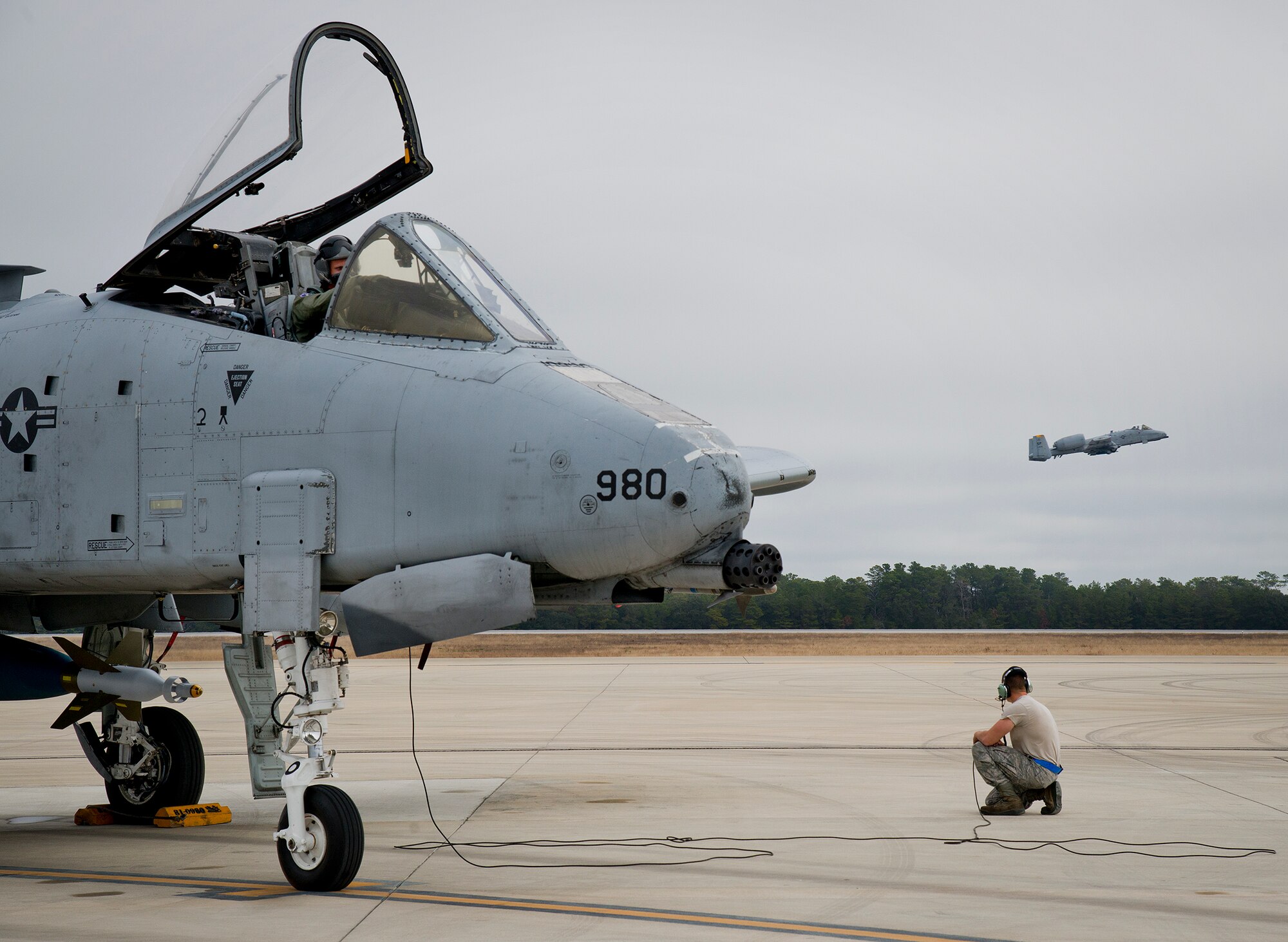 Airman Kevin Teto, of the 355th Aircraft Maintenance Squadron, watches an A-10 Thunderbolt II take off prior to launching his own aircraft for a sortie at Eglin Air Force Base, Fla., Feb. 19. The A-10s from Davis-Monthan Air Force Base, Ariz., participated in the week-long Weapon System Evaluation Program known as Combat Hammer, in which they released air-to-ground munitions.  The Combat Hammer WSEP program is managed by the 86th Fighter Weapons Squadron, part of the 53rd Wing.  (U.S. Air Force photo/Samuel King Jr.)
