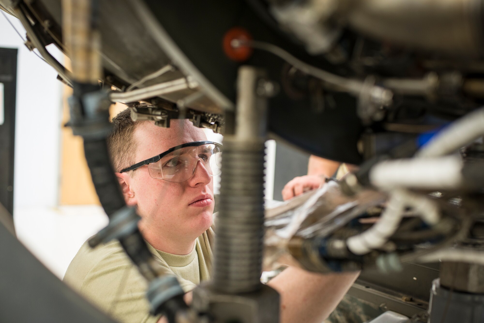 U.S. Air Force Airman 1st Class Matthew Pelletier, 23d Component Maintenance Squadron aerospace propulsion journeyman, tightens a clamp on the bottom of a TF34 engine at Moody Air Force Base, Ga., Feb. 19, 2014. Moody’s A-10C Thunderbolt II fleet is powered by dual TF34 engines. (U.S. Air Force photo by Airman 1st Class Ryan Callaghan/Released)