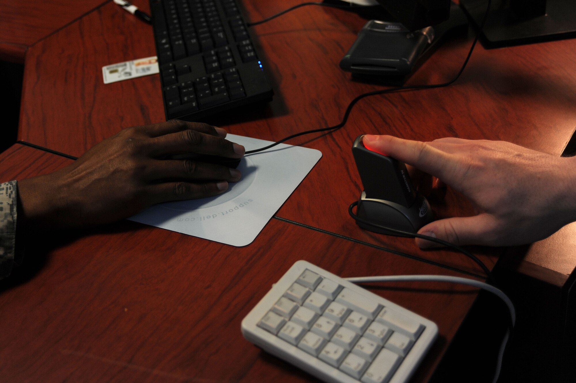 Staff Sgt. Jess Boese, 39th Operations Squadron air traffic controller, scans his finger for his new military identification card Feb. 20, 2014, Incirlik Air Base, Turkey.  Chief Master Sgt. Anthony Johnson, 39th Air Base Wing command chief, issued a new military ID cards during his visit to the 39th Force Support Squadron military personnel section. (U.S. Air Force photo by Senior Airman Nicole Sikorski/Released)