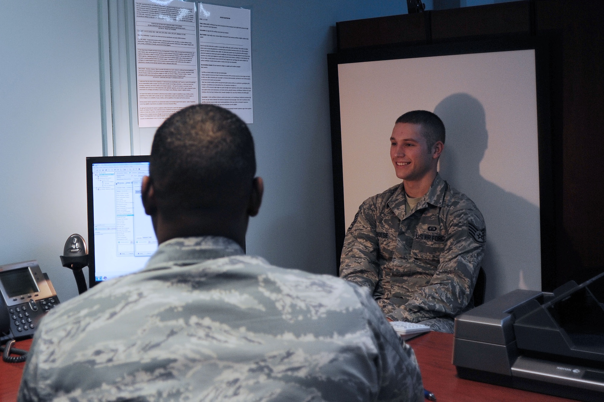 Chief Master Sgt. Anthony Johnson, 39th Air Base Wing command chief takes a photo of Staff Sgt. Jess Boese, 39th Operations Squadron air traffic controller, for a new military identification card Feb. 20, 2014, Incirlik Air Base, Turkey.  Johnson and Col. Craig Wills, 39th ABW commander, experienced a number of the daily duties of the 39th Force Support Squadron military personnel section. (U.S. Air Force photo by Senior Airman Nicole Sikorski/Released)