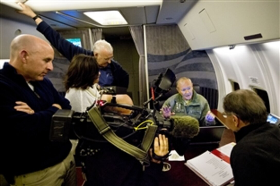 U.S. Army Gen. Martin E. Dempsey, chairman of the Joint Chiefs of Staff, talks with Jim Miklaszewski, NBC's chief Pentagon correspondent, and other reporters on a military aircraft en route to Afghanistan, Feb. 24, 2014. 