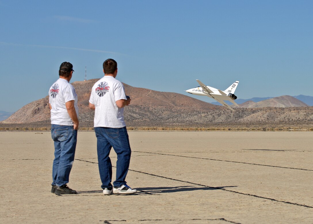 Brent Hecht (right) performs a high-speed, low-level fly-by, alongside his dad, Rodger, on the Rosamond Dry Lakebed Feb. 22. Rodger and Brent started flying radio-controlled models with the Muroc Model Masters R/C Club nearly 20 years ago and decided to build their 12-foot long T-38 Talon with an 82-inch wingspan. The fully-functional model weighs approximately 45 pounds, has two 5-inch electric ducted fans powered by brushless motors and the airframe is made of blue foam, carbon fiber, fiber glass, balsa wood and plywood. (U.S. Air Force photo by Jet Fabara)