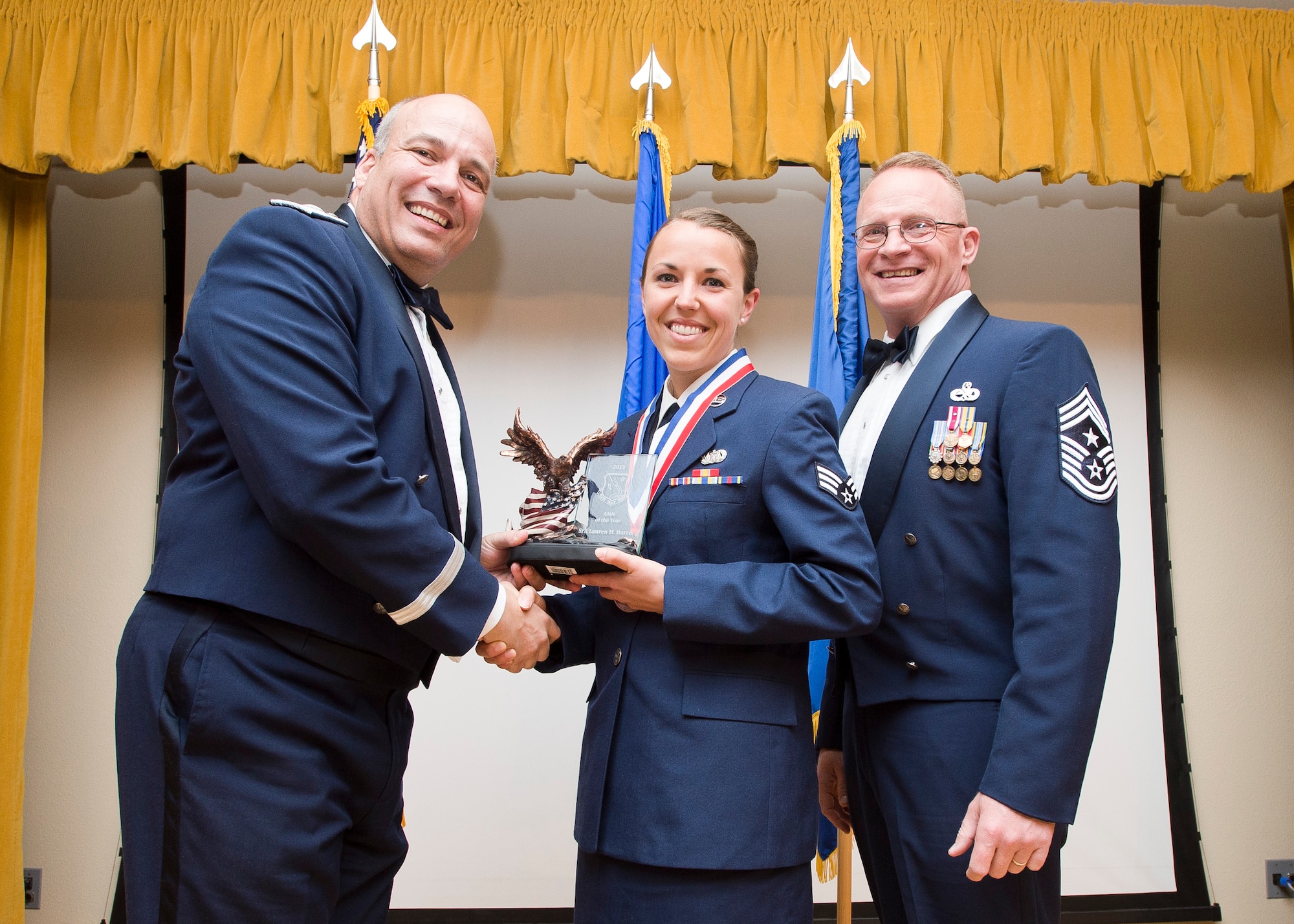 Airman Category Winner: Senior Airman Lauren Harris, 412th Test Wing Judge Advocate Office, is congratulated by (left)  Brig. Gen. Michael T. Brewer, 412th Test Wing commander, and Chief Master Sgt. Brian Randolph, 412th TW command chief. (U.S. Air Force photo by Ethan Wagner. 
