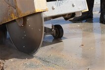 Airmen using a walk-behind wheel saw, belonging to the 36th Civil Engineer Squadron, cuts through the concrete around a damages area on the flightline during airfield damage repair training Jan. 23, 2014, on Andersen Air Force Base, Guam. The 36th Civil Engineer Squadron Airmen were the first in the Air Force to receive training on a new airfield damage repair capability.  (U.S. Air Force photo by Airman 1st Class Emily A. Bradley/Released)