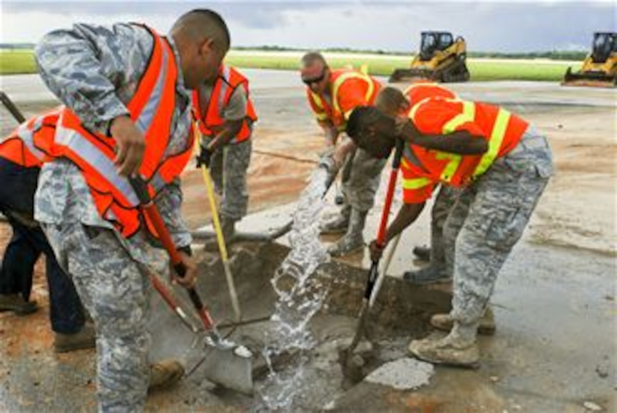 36th Civil Engineer Squadron Airmen mix water and a low-strength concrete together in the area where simulated damage was created during an airfield damage repair training exercise on the Andersen Air Force Base, Guam, flightline Jan. 23, 2014. The 36th Civil Engineer Squadron Airmen were the first in the Air Force to receive training on a new airfield damage repair capability. (U.S. Air Force photo by Airman 1st Class Emily A. Bradley/Released)