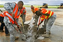 36th Civil Engineer Squadron Airmen mix water and a low-strength concrete together in the area where simulated damage was created during an airfield damage repair training exercise on the Andersen Air Force Base, Guam, flightline Jan. 23, 2014. The 36th Civil Engineer Squadron Airmen were the first in the Air Force to receive training on a new airfield damage repair capability. (U.S. Air Force photo by Airman 1st Class Emily A. Bradley/Released)