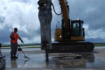 Staff Sgt. Austin Winegardner, 36th Civil Engineer Squadron project leader, directs Airmen operating heavy machinery to clear debris away from a simulated damaged area created during airfield damage repair training on the Andersen Air Force Base, Guam, flightline Jan. 23, 2014. The 36th Civil Engineer Squadron Airmen were the first in the Air Force to receive training on a new airfield damage repair capability.  (U.S. Air Force photo by Airman 1st Class Emily A. Bradley/Released)