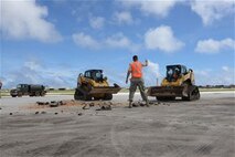 Staff Sgt. Austin Winegardner, 36th Civil Engineer Squadron project leader, directs Airmen operating heavy machinery to clear debris away from a simulated damaged area created during airfield damage repair training on the Andersen Air Force Base, Guam, flightline Jan. 23, 2014. The 36th Civil Engineer Squadron Airmen were the first in the Air Force to receive training on a new airfield damage repair capability.  (U.S. Air Force photo by Airman 1st Class Emily A. Bradley/Released)