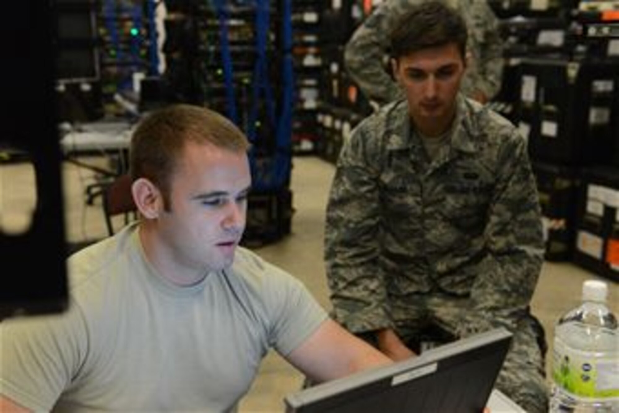 (From left) Staff Sgt. Richard Rawls, cyber systems supervisor, and Senior Airman Garett Savard, cyber systems operator, both from the 644th Combat Communications Squadron, update programs on one of the three transportable base servers Jan. 13, 2014, on Andersen Air Force Base, Guam. The 644th CBCS became aligned with the 36th Contingency Response Group to be able to support missions with smaller airlift requirements and faster reaction capabilities. (U.S. Air Force photo by Airman 1st Class Emily A. Bradley/Released)