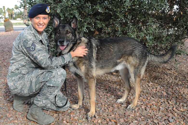 U.S. Air Force Staff Sgt. Alexandra Springman, 355th Security Forces Squadron military working dog handler, and retired military working dog, Dexter, 5-years-old, pose for a photo after his retirement ceremony at Davis-Monthan Air Force Base, Ariz., Feb. 19, 2014. Now that Dexter is a retired service member, he has been approved to reside with Springman as a member of her family. (U.S. Air Force photo by Airman 1st Class Chris Drzazgowski/Released)