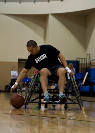 Senior Airman Grovert Fuentes, Air Force Public Affairs Agency photojournalist, practices dribbling techniques during the adaptive sports basketball clinic Feb. 26, 2014, at Nellis Air Force Base, Nev.  Fuentes is participating in the three-day Air Force Wounded Warrior Adaptive Sports Camp event which offers a variety of sport’s clinics to service members from across the country. (U.S. Air Force photo by Senior Airman Jason Couillard)