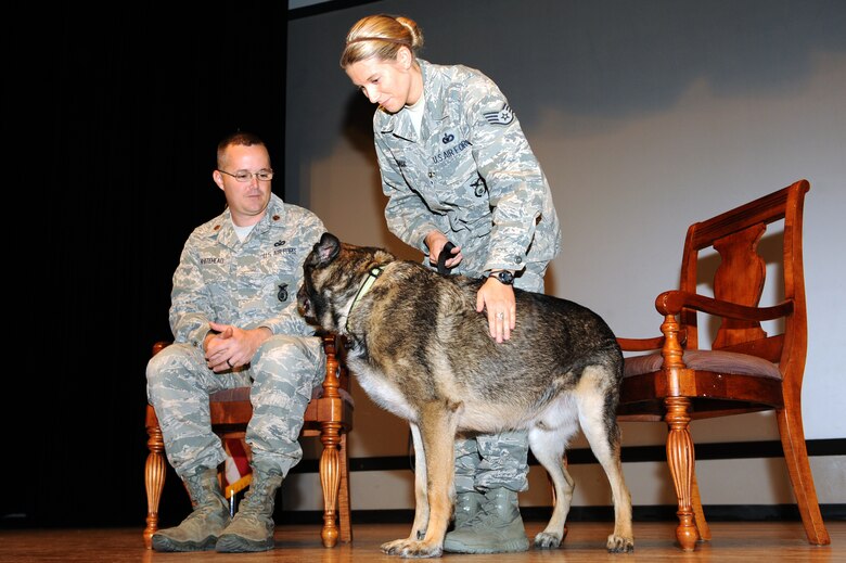 U.S. Air Force Staff Sgt. Alexandra Springman, 355th Security Forces Squadron military working dog handler, pets Dexter, 5-years-old, 355th SFS military working dog, during his retirement ceremony at Davis-Monthan Air Force Base, Ariz., Feb. 19, 2014. During his military service, Dexter has deployed to Iraq and Saudi Arabia where he served as a dual purpose dog. (U.S. Air Force photo by Airman 1st Class Chris Drzazgowski/Released)