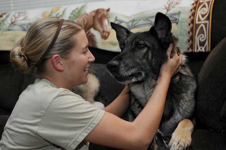 U.S. Air Force Staff Sgt. Alexandra Springman, 355th Security Forces Squadron military working dog handler, pets Dexter, a retired MWD, in Tucson, Ariz., Feb. 25, 2014. Springman adopted Dexter after he retired for the Air Force due to a medical condition. (U.S. Air Force photo by Airman 1st Class Betty R. Chevalier/Released)
