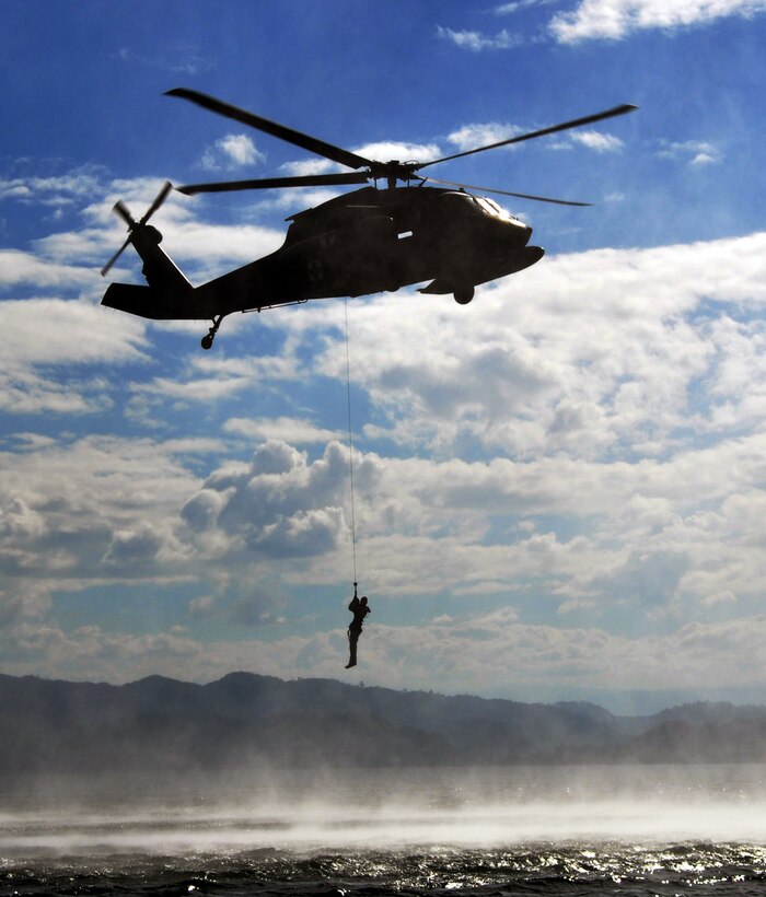 A member of Joint Task Force-Bravo is hoisted from the waters of Lake Yojoa, Honduras, during a training exercise, Feb. 25, 2014. Joint Task Force-Bravo and members of the 7th Special Forces Group (Airborne) conducted helocast, caving ladder and overwater hoist training during the exercise in order to maintain proficiency in a variety of skill sets as well as to prepare for future operations and exercises throughout Central America. (U.S. Air Force photo by Capt. Zach Anderson)