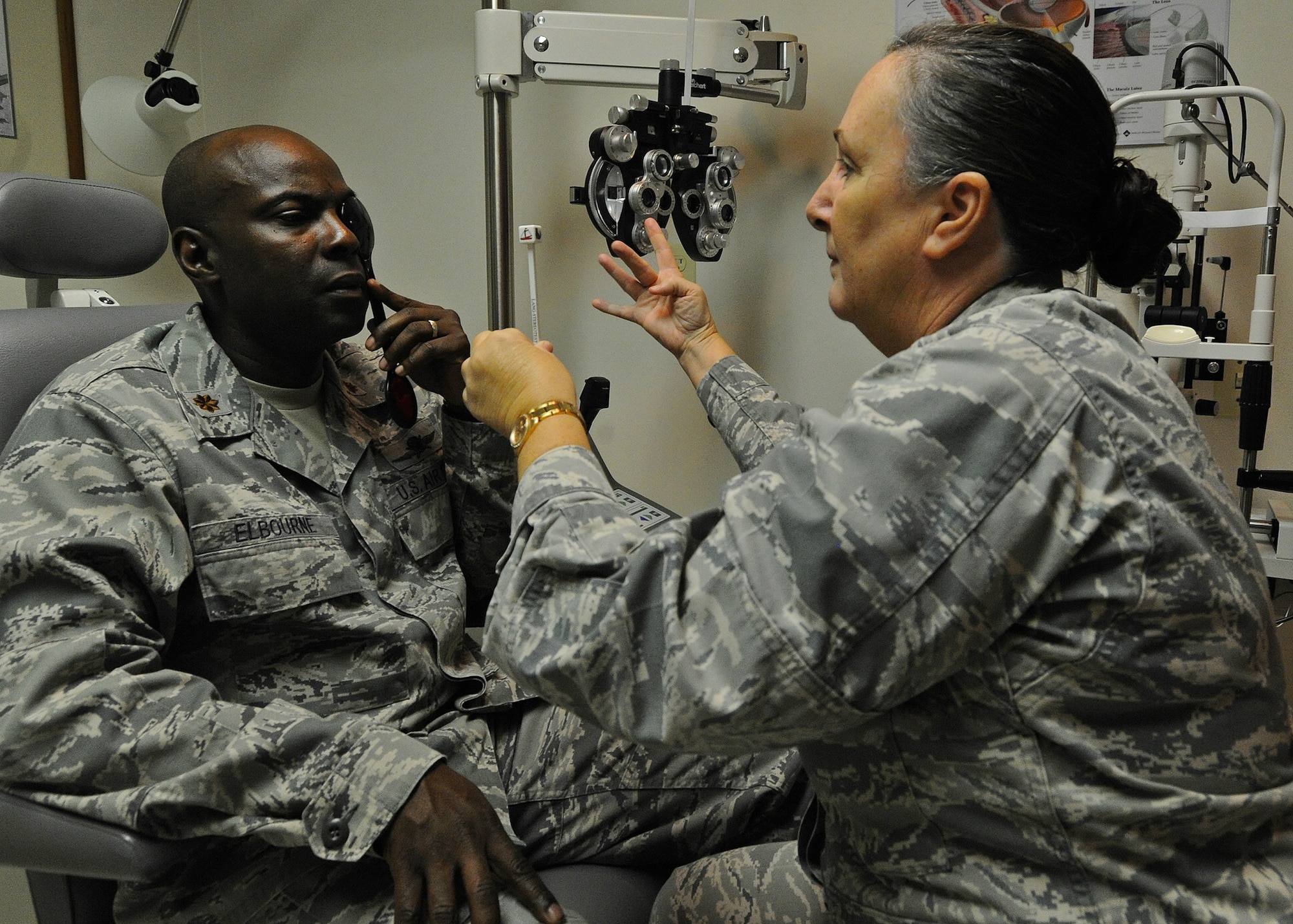 Maj. Alane Durand, 15th Aerospace Medicine Squadron Optometry Element chief, right, tests the vision of Maj. Callistus Elbourne, Pacific Air Forces Air Postal Squadron commander, left, during a routine eye exam at the optometry clinic on Joint Base Pearl Harbor-Hickam, Hawaii, Feb. 24, 2014. The American Optometric Association recommends that everyone has an exam at least every three years. (U.S. Air Force photo/Master Sgt. Jerome S. Tayborn)