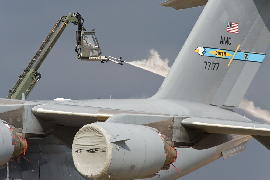 Airman First Class Jacob Riddle, 736th Aircraft Maintenance Squadron crew chief, sprays deicing fluid on the tail of a C-17A Globemaster III Feb. 26, 2014, at Dover Air Force Base, Del. The local area received about an inch of snow from the latest storm to pass through. (U.S. Air Force photo/Roland Balik)