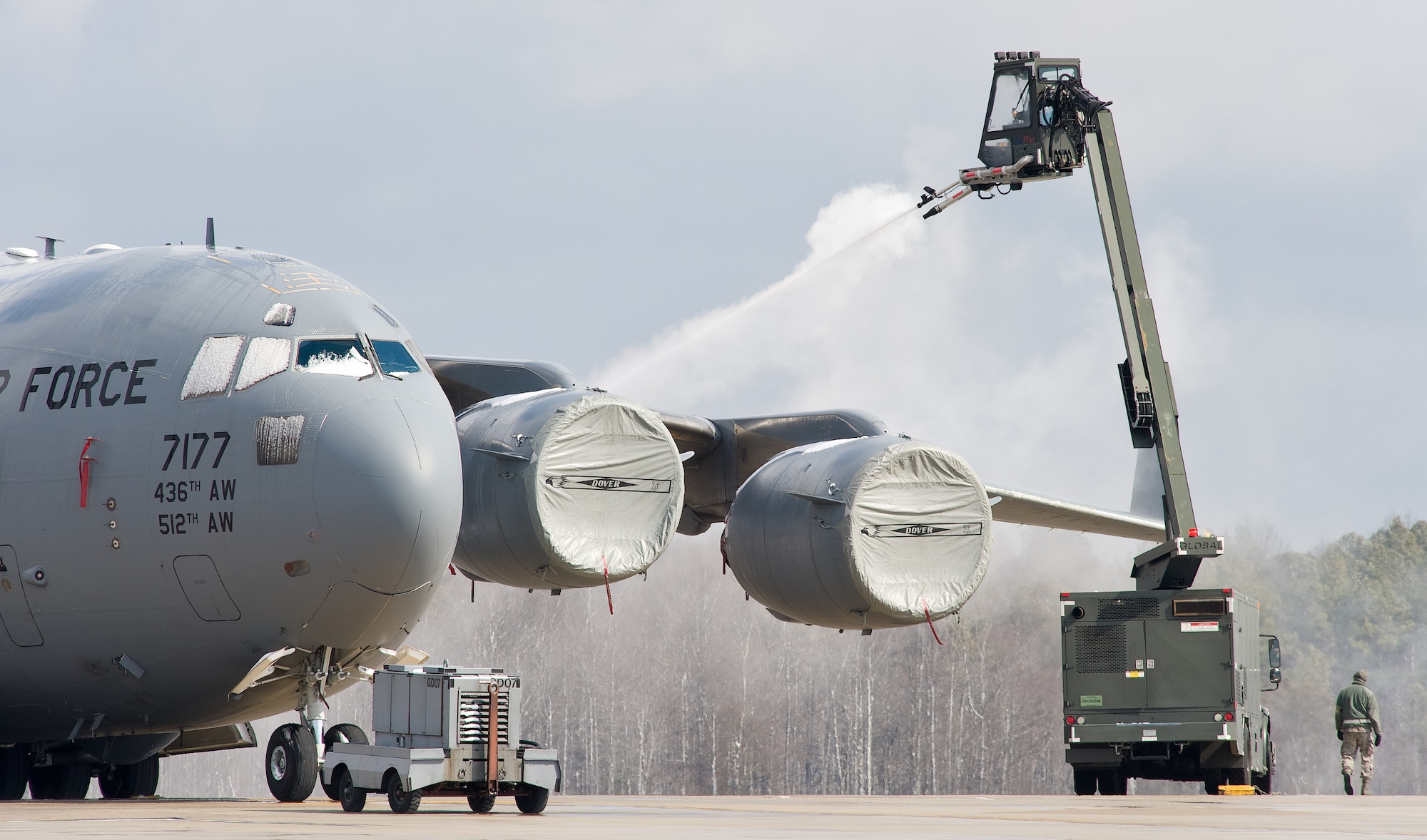 Airman First Class Brandon Lawrence from the 736th Aircraft Maintenance Squadron, sprays deicing fluid on the wing and engines of a C-17A Globemaster III Feb. 26, 2014, at Dover Air Force Base, Del. The base received almost an inch of snow by noon. (U.S. Air Force photo/Roland Balik)