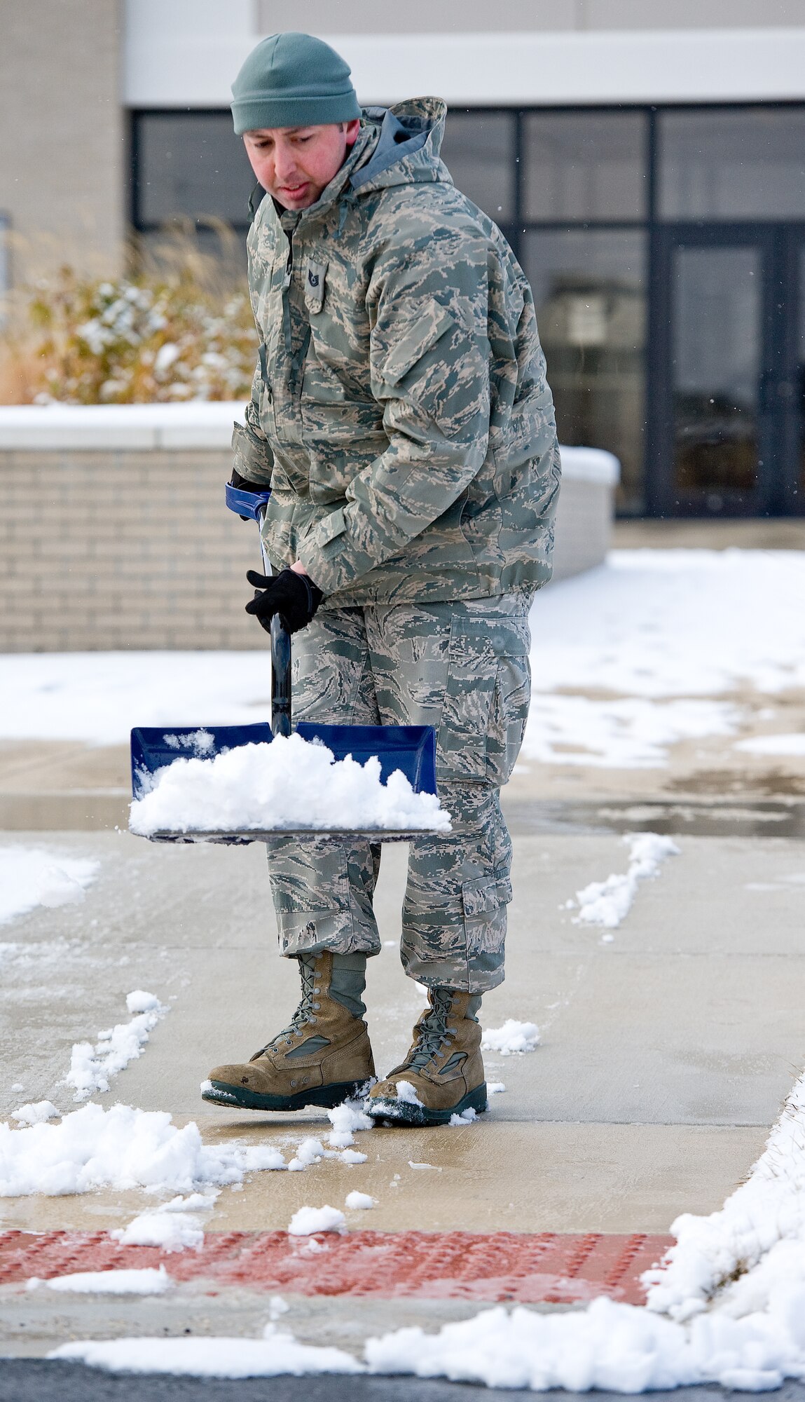 Tech. Sgt. Victor Santillan, 436th Airlift Wing noncommissioned officer in charge of chapel operations, shovels snow off the sidewalk Feb. 26, 2014, at the base chapel on Dover Air Force Base, Del. Snow fell from 7 a.m. to 12 p.m. and gave away to sunny skies and cold temperatures. (U.S. Air Force photo/Roland Balik)