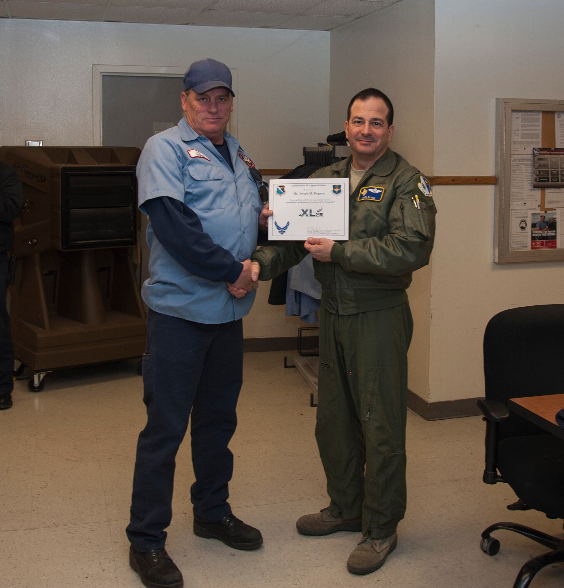 Joseph Degnan, left, 47th Maintenance Directorate T-38 Talon aircraft engine mechanic, poses with Col. Mark Doria, right, 47th Flying Training Wing vice commander, after being presented the XLer of the week award here Feb. 12, 2014. The XLer is a weekly award chosen by wing leadership and given to those who consistently make outstanding contributions to Laughlin and their unit. (U.S. Air Force photo/Airman 1st Class Jimmie D. Pike)