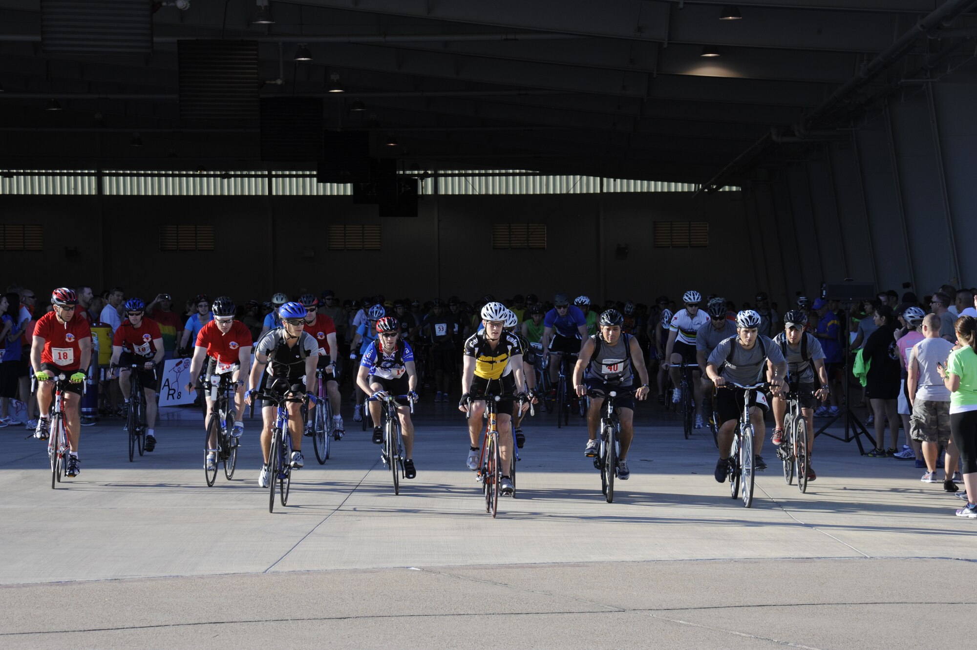 Bikers exit the weather hangar during Adventure Race VIII at Laughlin Air Force Base, Texas,  April 21, 2012. Adventure Race began in 2004 and has grown into a major event for the Del Rio and Laughlin Communities. More than 5,000 people have competed in the race across Val Verde County. This year the race will be held on May 3.(U.S. Air Force photo/Airman 1st Class Nathan Maysonet)