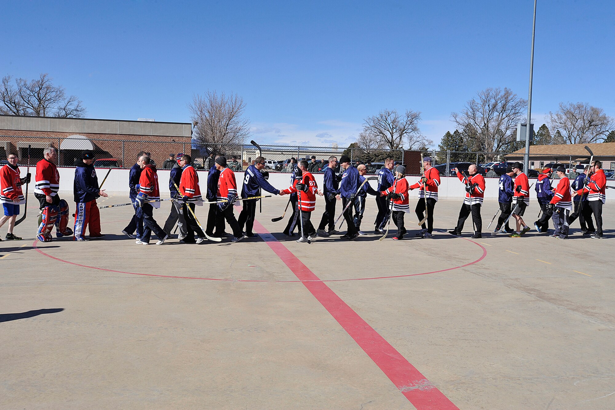 PETERSON AIR FORCE BASE, Colo. -- The U.S. and Canadian Hockey teams shake hands after the USA vs. Canada Ball Hockey Tournament held at Peterson Air Force Base Feb. 21. The tournament was a best of three series between teams made up of junior Airmen, junior leadership and senior leadership. Team Canada won the first two games and the series with scores of 6-0 in the junior enlisted game and 7-4 in the junior leadership game. Team USA avoided a shutout by defeating Team Canada in the senior leadership game 6-2. (U.S. Air Force photo/Dennis Howk)