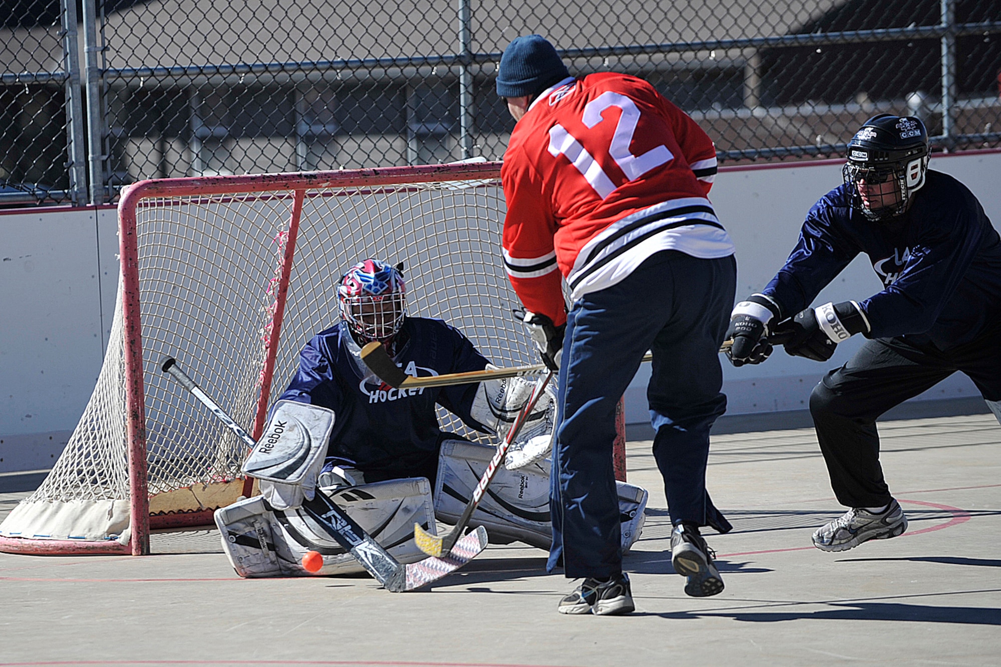 PETERSON AIR FORCE BASE, Colo. -- Lt. Col. Miguel Rosales Jr. makes a save against Capt. Trygve Fischer during the USA vs. Canada Ball Hockey Tournament at the Peterson Roller Hockey Rink Feb. 21. Canada won this game 7-4. The tournament was a best of three series between teams made up of junior Airmen, junior leadership and senior leadership. Team Canada won the first two games and the series with scores of 6-0 in the junior enlisted game and 7-4 in the junior leadership game. Team USA avoided a shutout by defeating Team Canada in the senior leadership game 6-2. (U.S. Air Force photo/Robb Lingley)