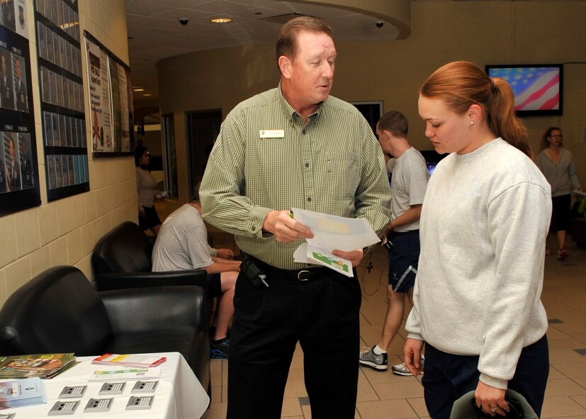 Todd Makamson, Airman & Family Readiness Center director of personal financial management, gives Senior Airman Amber Rodriguez, 2nd Operations Squadron air traffic controller, flyers explaining financial benefits of saving money and reducing debt. "The information can be useful," said Rodriguez. "It can help Airmen keep track of their spending, especially with the current cutbacks." (U.S. Air Force photo/Airman 1st Class Benjamin Raughton)
