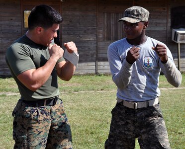 A U.S. Marine instructs a Honduran marine during training at a Honduran military installation in La Ceiba, Honduras, Feb. 12, 2014.  Members of U.S. Marine Forces South's Security Cooperation Team are conducting partnered training in several Central American countries in order to help build partner nation capacity and promote stability throughout the region.  (U.S. Air Force photo by Capt. Zach Anderson)   