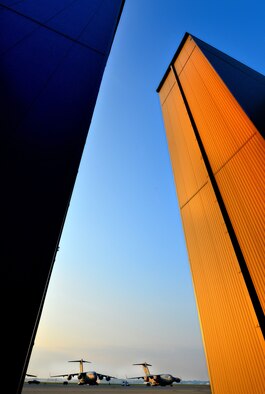 WRIGHT-PATTERSON AIR FORCE BASE, Ohio - Two hangars at the 445th Airlift Wing frame the wing's C-17 Globemaster IIIs sitting on the ramp, capturing the sun rise over the flightline at Wright Patterson Air Force Base, Ohio. Maintainers from the 445th Aircraft Maintenance Squadron begin to prep one of the C-17s for a morning flight. (U.S. Air Force photo/Tech. Sgt. Frank Oliver) 