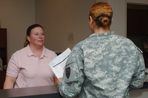 Christy Silva, 733rd Force Support Division volunteer program manager, assist an Army Community Service customer at Fort Eustis, Va., Feb. 20, 2014. ACS provides workshops and individual consultations for active duty Service members, families, Department of Defense civilians, contractors and retirees. Silva hails from Newport News, Va. (U.S. Air Force photo by Airman 1st Class Areca T. Wilson/Released)